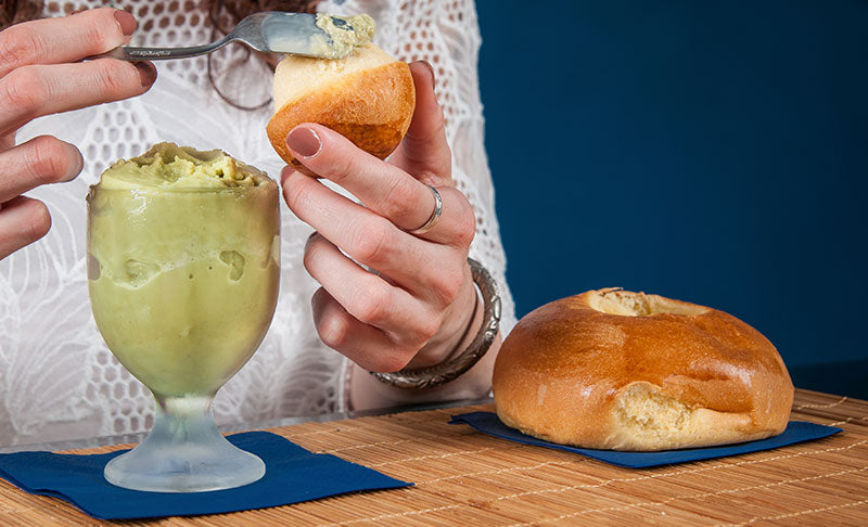 Frau streicht Granita auf den Tuppo einer siziiianischen Brioche